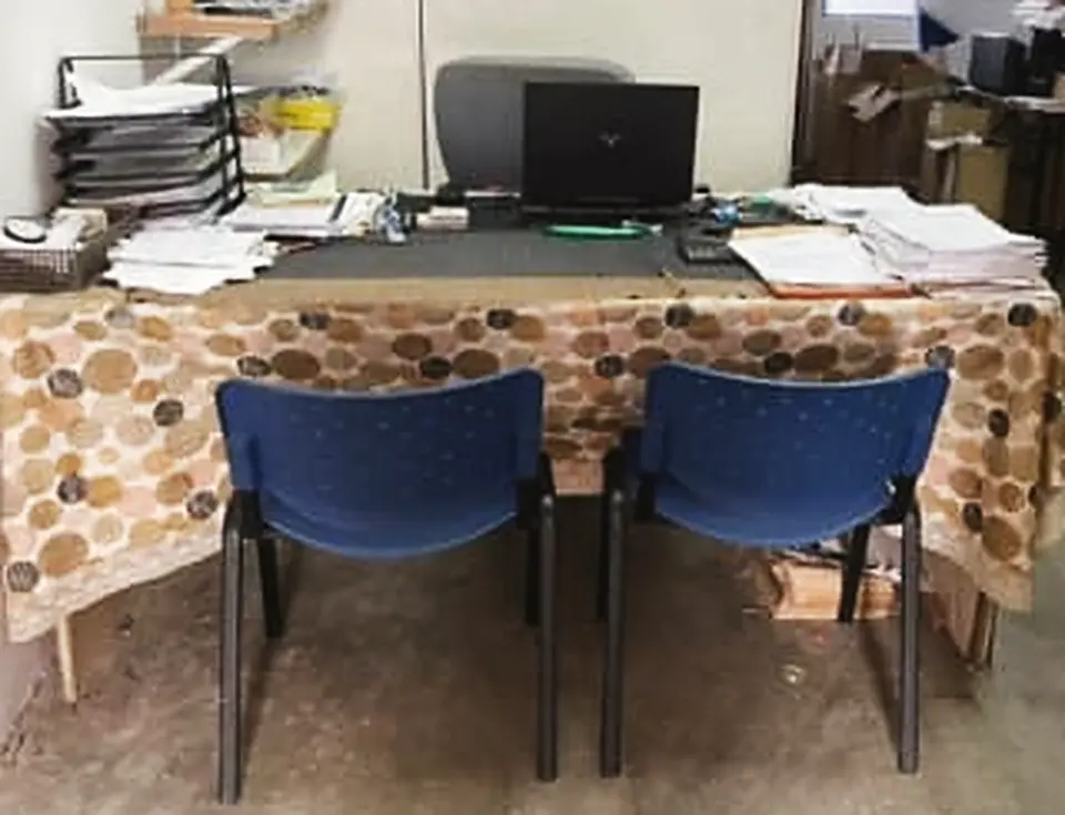 Meja kerja dengan komputer riba dan fail pelan di pejabat DNC Enterprise